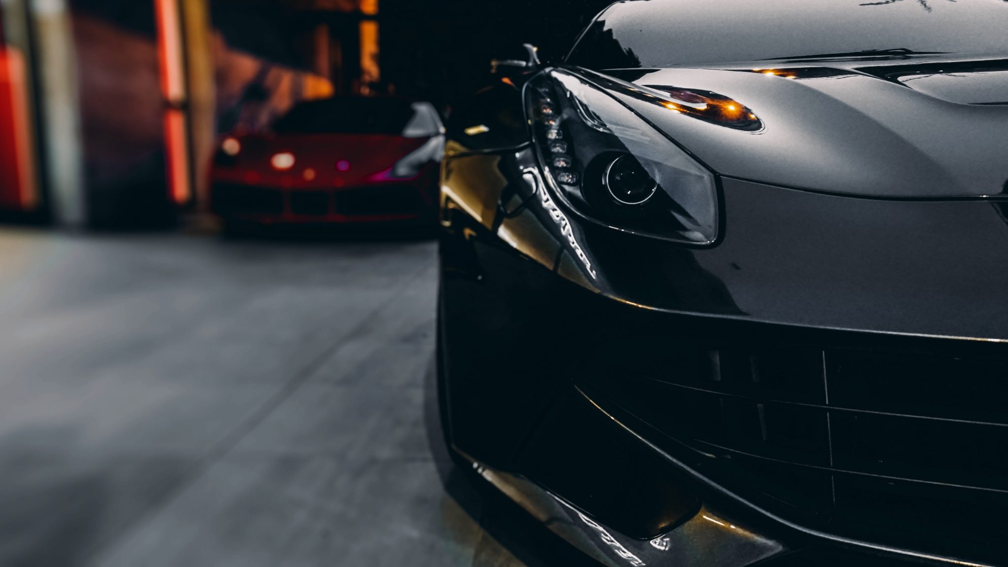 Sleek silver sports car parked at night with illuminated headlights and warm ambient lighting