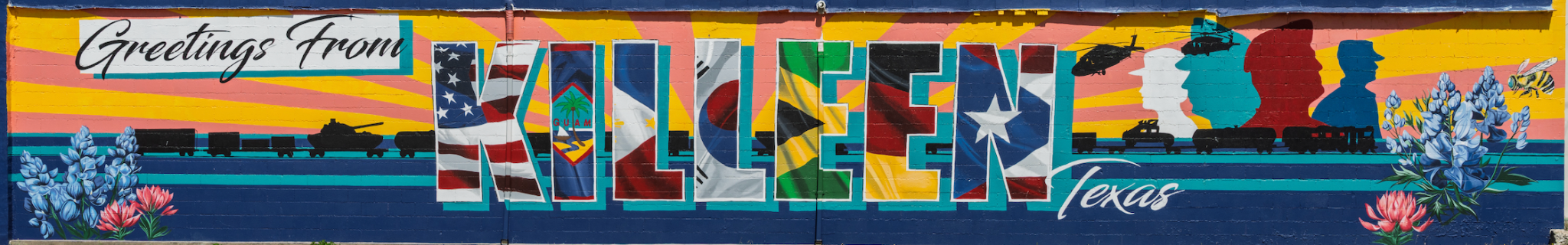 Colorful mural reading "Greetings From Killeen Texas" with state flags, bluebonnets, and desert landscape imagery